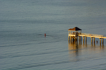 Unknown people fishing at gazebo at sea coast