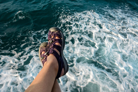 transportation image of close up legs on ferry boat over sea water