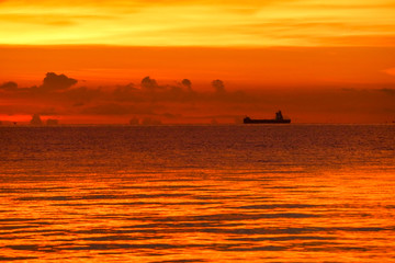 Naklejka na ściany i meble sunset on sea and ocean last light red sky silhouette cloud