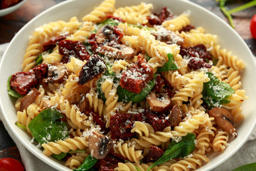Fusilli Pasta with sun dried tomatoes, mushrooms, parmesan cheese and spinach. healthy food.