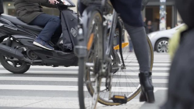 Woman on a bike waiting for car traffic in Paris France