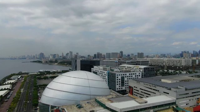 A shot of the Metro Manila skyline, ocean side and buildings and a big dome.