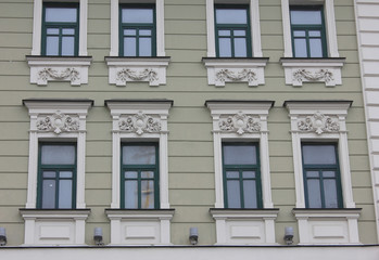 Fototapeta na wymiar Old historical building facade of classic european house with windows in Moscow, Russia. Russian city typical architecture, close up view of building front facing the street