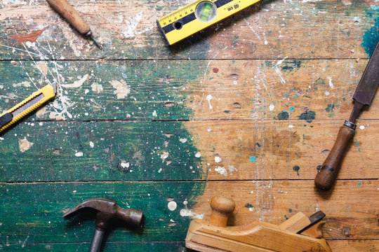 Flat lay set of vintage carpentry tools on colorful wooden background. Top view workbench with carpenter different tools. DIY, woodworking, craftsmanship and handwork concept 
