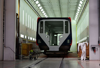 Inside of the rail car assembly plant. Industrial workshop for the production of European high speed trains. Painting a train at the Stadler Minsk rolling stock plant