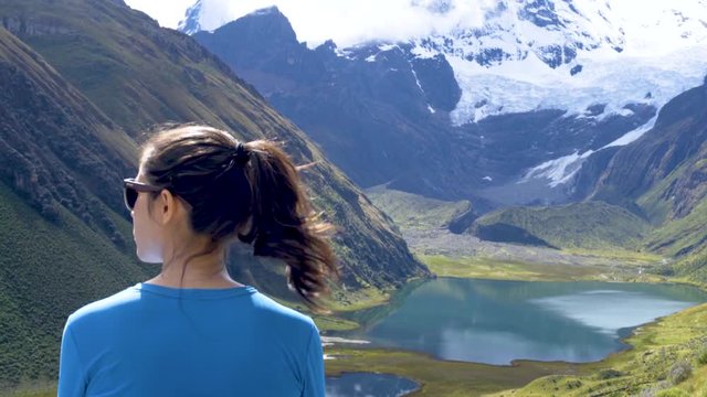 girl hiking and checking view relax on the mountains enjoying sunslight on a beautiful scenary in Huayhuash in Peru
