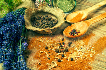 Various dried and fresh spices on the wooden table .