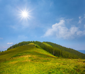 Fototapeta na wymiar green mount top under a sparkle sun, summer natural background