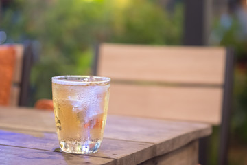 Glass of alcohol with ice cubes on the table