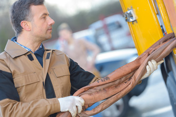 man removing hose from vehicle