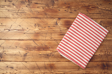 Wooden tabletop with striped tablecloth for kitchen or cooking food background. Top view from above