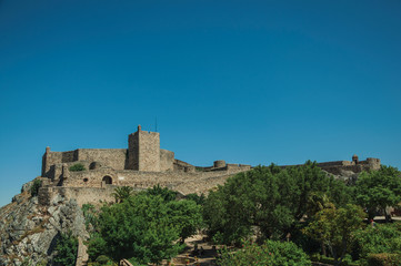Stone walls and tower of Castle over hill near garden at Marvao