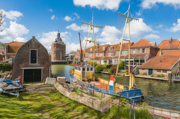 Fishing boat in Enkhuizen in the Netherlands with the historic city gate (Drommedaris) in the...