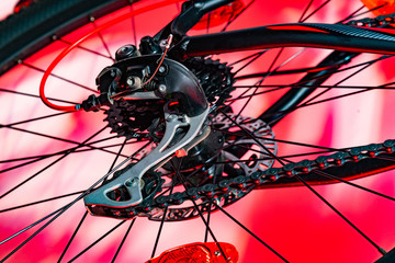 Obraz premium close-up shot of new bicycle rear derailleur in red artificial lightning