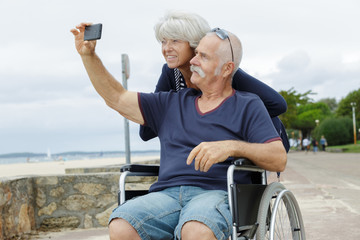 senior couple in wheelchair taking a selfie