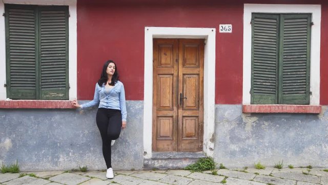 white girl in front of a colorful red house in Burano