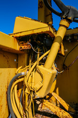 rusty old abandoned yellow construction vehicle steering colum cab and wiring pipes