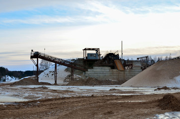 Sand mining in winter conditions in an industrial quarry. Conveyor Belt in mining quarry, Mining industry. Amazing mountains against the backdrop of snow and industry