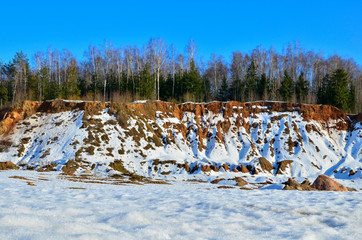 View of the small mountains in the open-pit with pines and spruces in the snow in winter. This place is located in the Belarus Minsk region, the village of Praleski, mining quarry Radashkovichi.