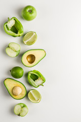 Green vegetables and fruits on white background