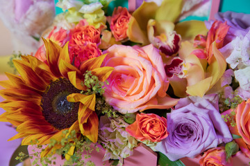 Colorful mixed bouquet with various spring flowers in floral decor, Colorful wedding flowers background . Mixed flower arrangement: various flowers in different shades of red, pink, yellow and orange.