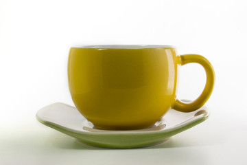 Yellow cup with saucer in the white background