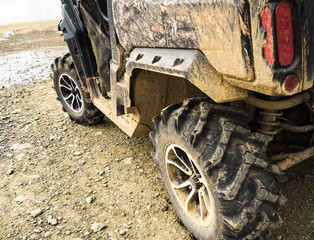 Closeup of dirty buggy wheels. ATV quad vehicle on off-road track