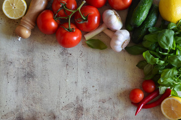 Tomatoes, cucumbers, garlic heads, fresh Basil, hot pepper and lemons on the table. Beautiful composition of fruits and vegetables.