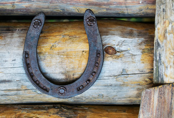 Horseshoe, hanging on a wooden bar, a symbol of good luck and wealth.