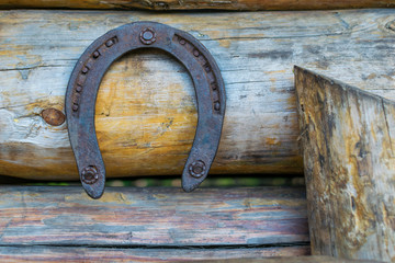 Horseshoe, hanging on a wooden bar, a symbol of good luck and wealth.