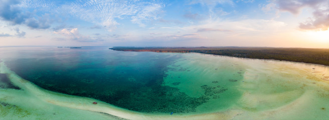 Aerial view tropical beach island reef caribbean sea dramatic sky at sunset sunrise. Indonesia...