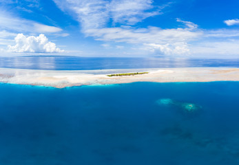 Fototapeta na wymiar Aerial idyllic atoll, scenic travel destination Maldives Polinesia. Blue lagoon and turquoise coral reef. Shot in Wakatobi National Park, Indonesia