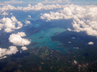 Top view landscape Island mountain and coast with blue sea ocean and white clouds. View from airplane while flying over Andaman sea in Thailand.