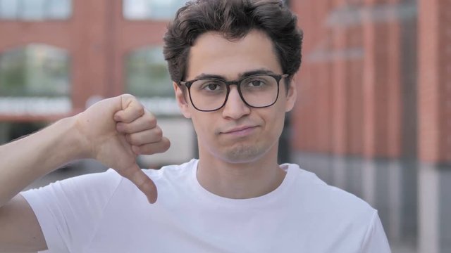 Thumbs Down by Young Man Standing Outdoor