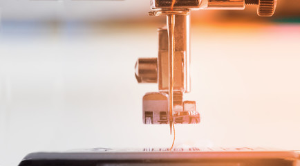 sewing machine with colour thread and needle on a table with blurred background, Tailor's work table, textile or fine cloth making, industrial fabric, home appliances tool.