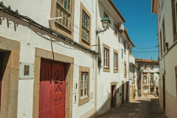 Fototapeta na wymiar Old houses with whitewashed wall in cobblestone alley