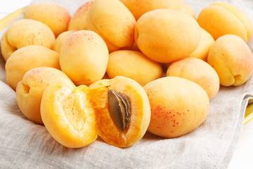 Fototapeta na wymiar Closeup image of ripe apricot fruits on a cloth napkin. Shallow focus.