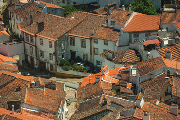 Cityscape with many rooftops and a cobblestone alley