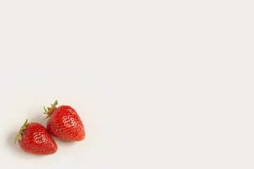 Two fresh red strawberries on white background