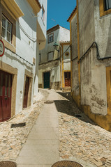 Old houses with whitewashed wall in cobblestone alley