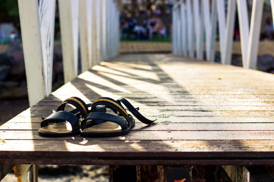 female sandals on a pier wooden smooth perspective surface, vintage style photography in sunny summer day time wallpaper pattern concept with empty space for copy or text