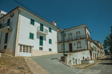 Old houses on street and deserted alley coming out on slope