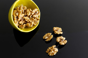 Walnuts spilled on the black table.