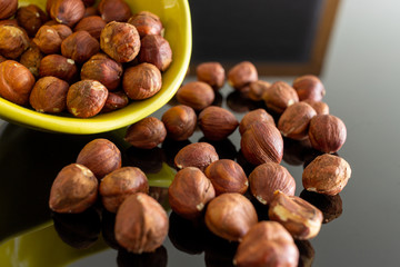 Hazelnuts spilled on the black table.