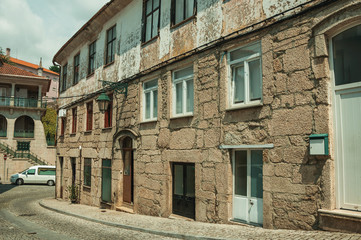 Fototapeta na wymiar Old houses with stone wall in a deserted alley