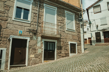 Old houses with stone wall in a deserted alley