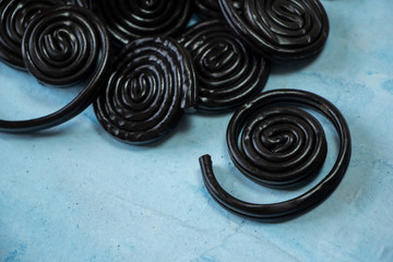 Detail of licorice candy spirals on blue background