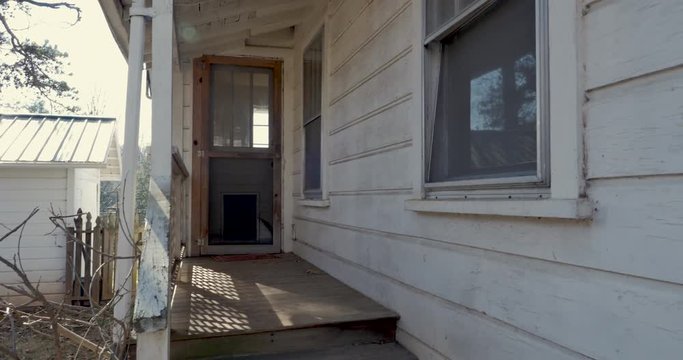 Tilt up of a back door entrance of a home and window with a misaligned screen