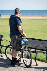 Naklejka premium unknown middle aged man on a bike ride takes a break to think about his life
