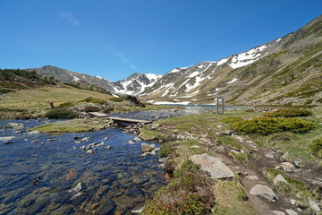 France Pyrenees mountain landscape, stream and Trebens lake with Carlit massif in background, natural park of the Catalan Pyrenees